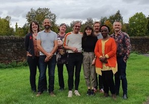 Group of smiling people stood together outside